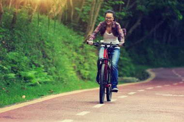 neşeli genç kadın bisikletçi orman iz üzerinde Bisiklete binme