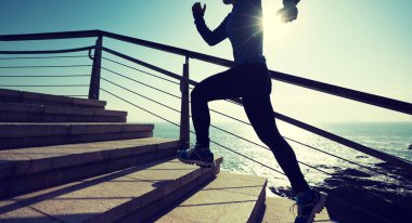 sahil yolu üzerinde yukarı çalışan sportif kadın runner