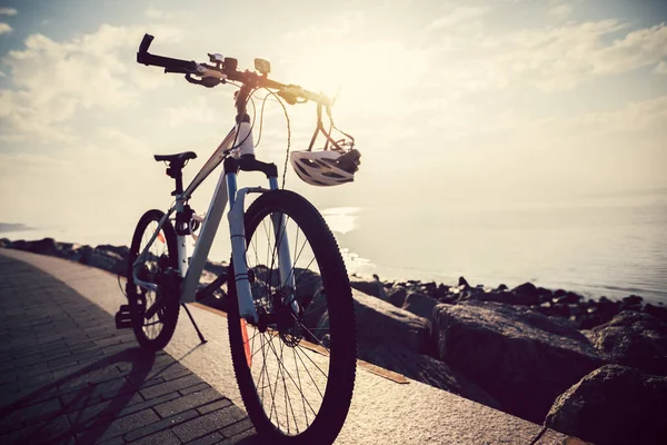 山自行车在日出海边的头盔 — 图库照片