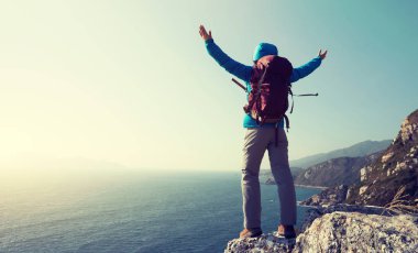 gündoğumu sahil dağ uçurumun kenarında duran başarılı kadın uzun yürüyüşe çıkan kimse