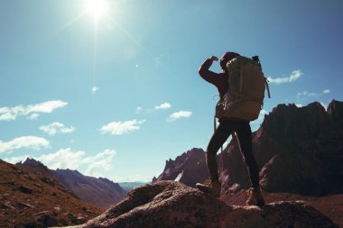 gündoğumu dağın tepesinde hiking sırt çantası ile kadın silüeti