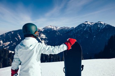 Kış zirvesinde snowboard yapan bir snowboardcu.