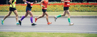 Şehir yolunda koşan maraton koşucusu bacakları