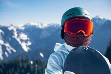 Kış zirvesinde snowboard yapan bir snowboardcu.