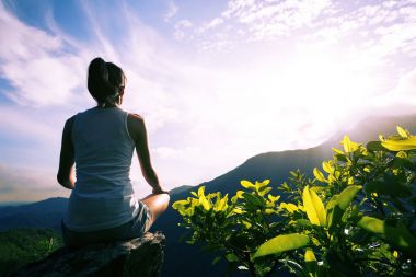Genç yoga kadın gündoğumu dağ tepe uçurumun kenarında