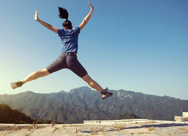 成功した女性ハイカーが山の頂上でジャンプ — ストック写真