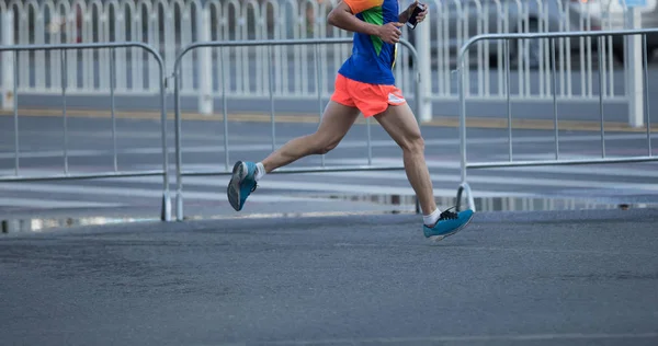 马拉松运动员腿在城市道路上奔跑 — 图库照片
