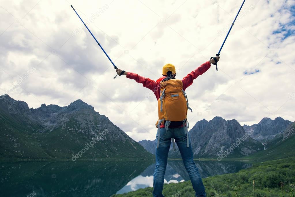 cheering backpacking woman hiker hiking in mountains