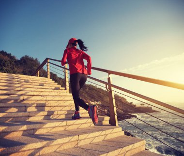sahil yolu üzerinde yukarı çalışan sportif kadın runner