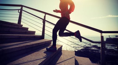 sahil yolu üzerinde yukarı çalışan sportif kadın runner