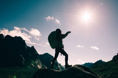 gündoğumu dağın tepesinde hiking sırt çantası ile kadın silüeti 