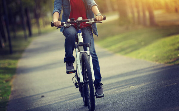 woman cyclist riding bike in tropical park