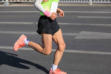 Şehir yolunda koşan maraton koşucusu bacakları