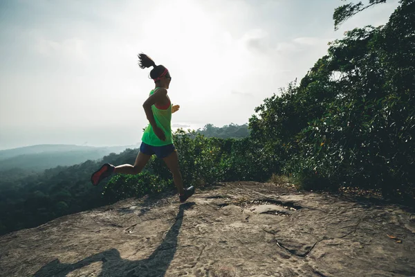 stock image Young asian woman running on mountain peak 