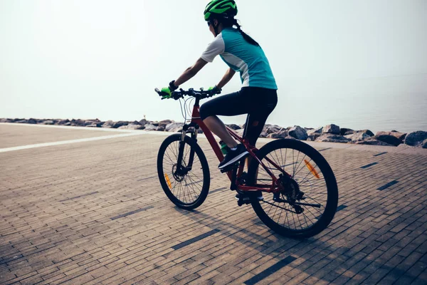 Dişi Bisikletçi Deniz Kenarında Dağ Bisikleti Sürüyor — Stok fotoğraf