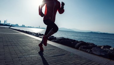 Sportif genç fitness kadın gündoğumu sahil üzerinde çalışan