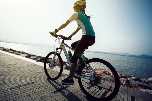海辺でマウンテンバイクに乗る女性サイクリスト — ストック写真