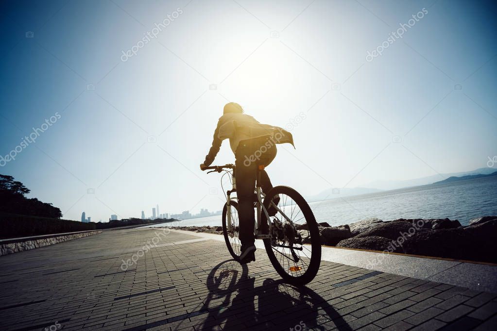 cyclist riding bike in the sunrise coast road