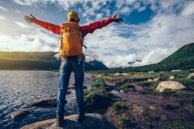 waterside üzerinde uzanmış kollarıyla tezahürat backpacking kadın