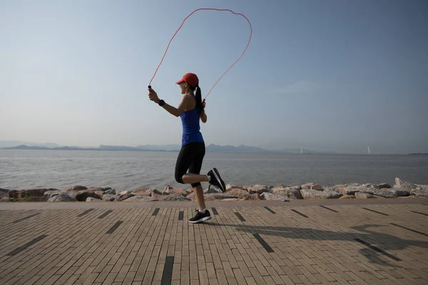 年轻健身运动员跳绳在海岸上 — 图库照片