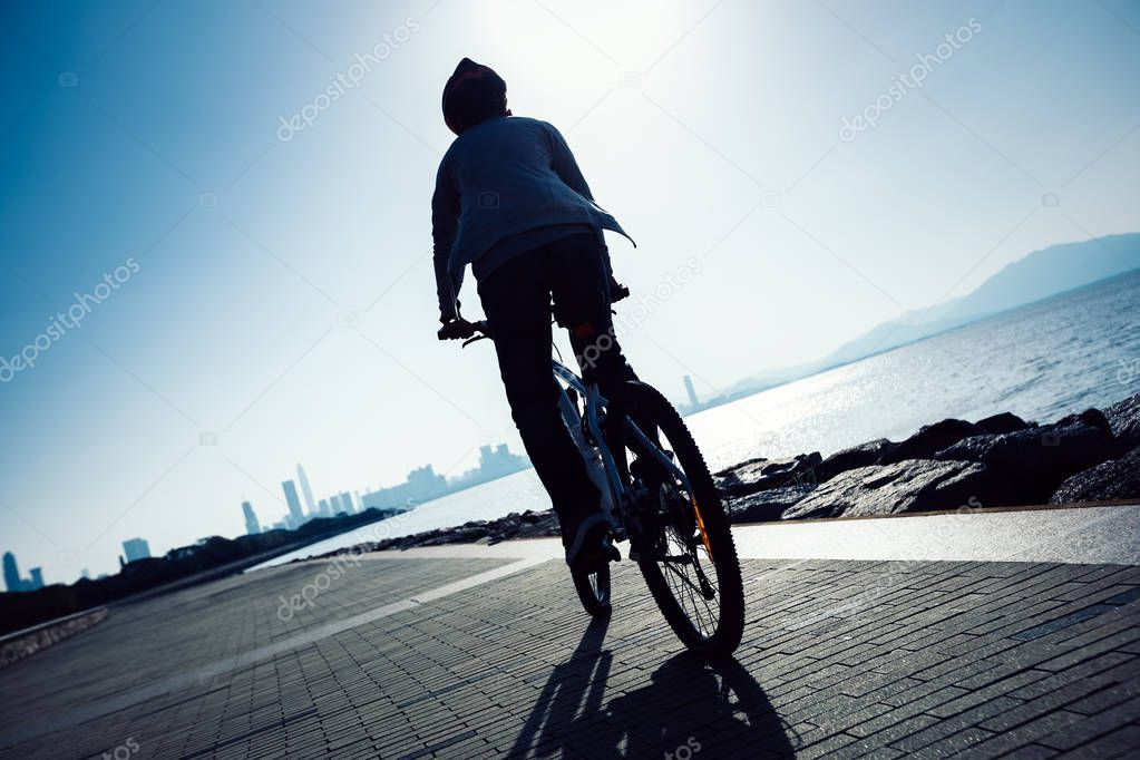 cyclist riding mountain bike on seaside