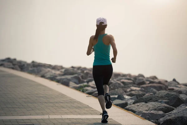 运动的年轻健身妇女在海岸小道上奔跑 — 图库照片