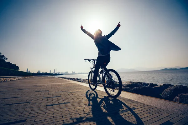 在日出海岸骑自行车的快乐骑车的剪影 — 图库照片