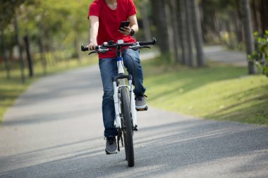 tropikal Park'taki bisiklet sürme sırasında cep telefonu kullanarak bisikletçi