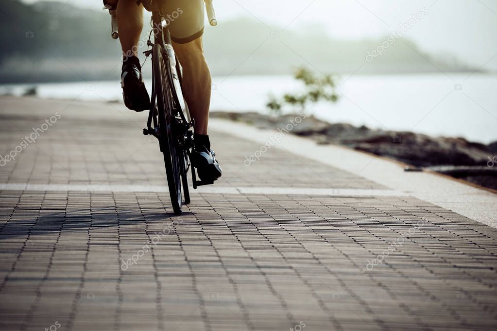 Male cyclist riding bike on seaside