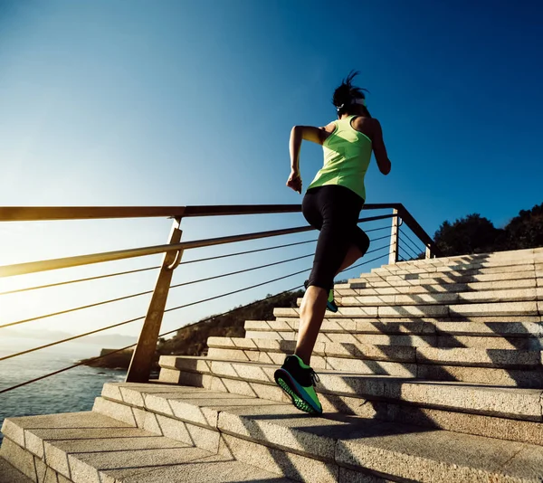 海辺の階段を駆け上がるスポーツフィットネス女子ランナー — ストック写真