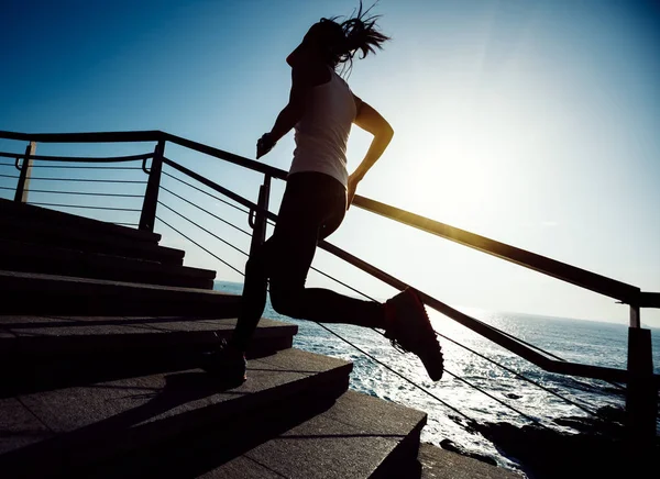 海辺の階段を駆け上がるスポーツフィットネス女子ランナー — ストック写真