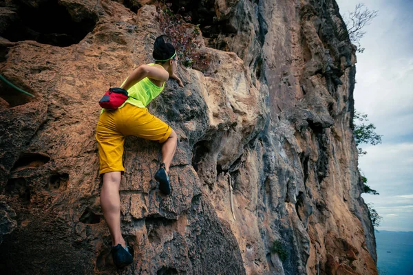 海辺の崖に登って女性ロック クライマー — ストック写真
