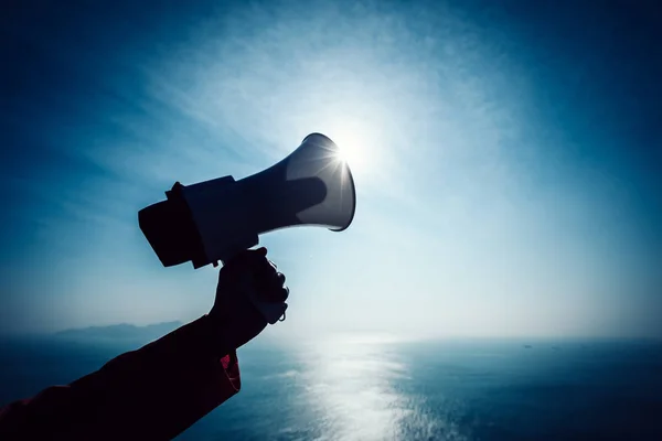 Mano Mantenga Megáfono Contra Mar Bajo Fondo Del Cielo — Foto de Stock