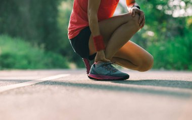 Kadın atlet orman iz üzerinde çalışırken spor yaralanma var