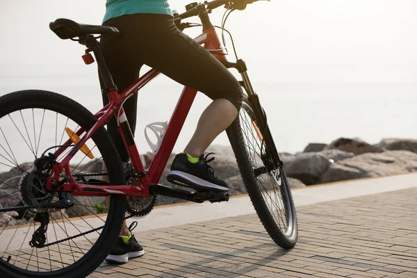 在海滨骑山地自行车的女骑手 — 图库照片