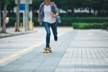 kadın kahve fincanı el ile şehir sokakta kaykay