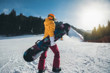 Genç kadın kış dağlarda snowboard