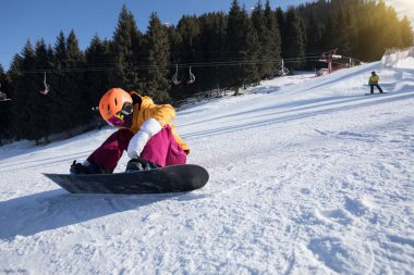 Genç kadın kış dağlarda snowboard