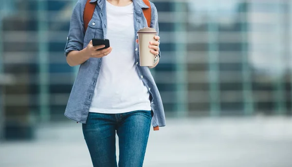 Mujer Usando Teléfono Móvil Mientras Camina Con Taza Café Mano —  Fotos de Stock