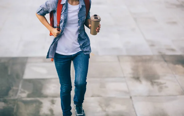 Woman walking with coffee cup in hand