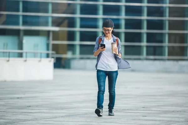 Donna Che Utilizza Telefono Cellulare Mentre Cammina Con Tazza Caffè — Foto Stock