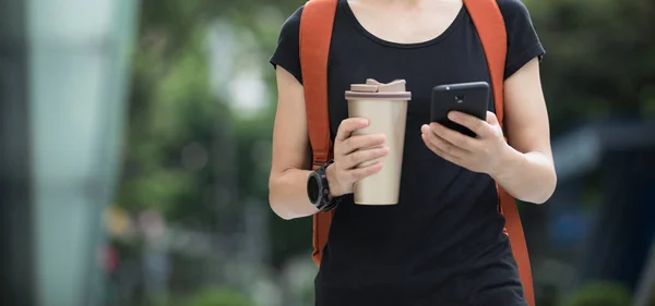 Chodzenie Kubkiem Kawy Ręku Przy Użyciu Telefonów Komórkowych Ulicy Miasta — Zdjęcie stockowe