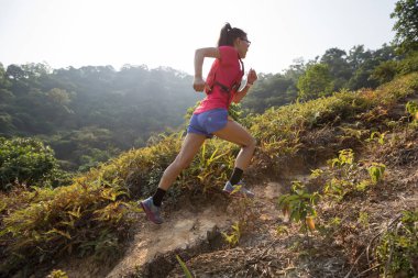Tropikal ormanlardaki dağ yamacında koşan kadın izleri.