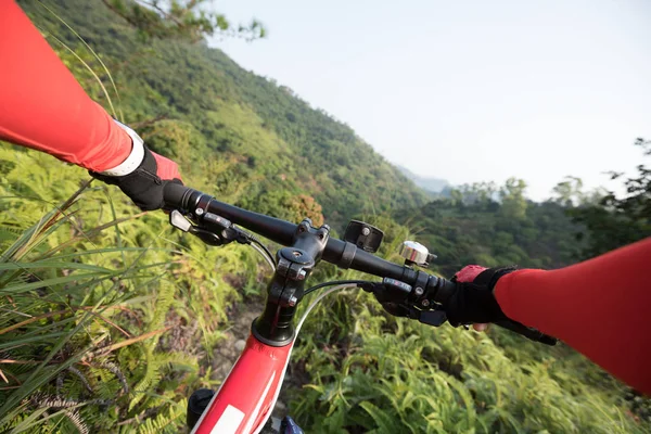 越野单车手牵着车把骑山地车下山在热带森林小径斜坡上 — 图库照片