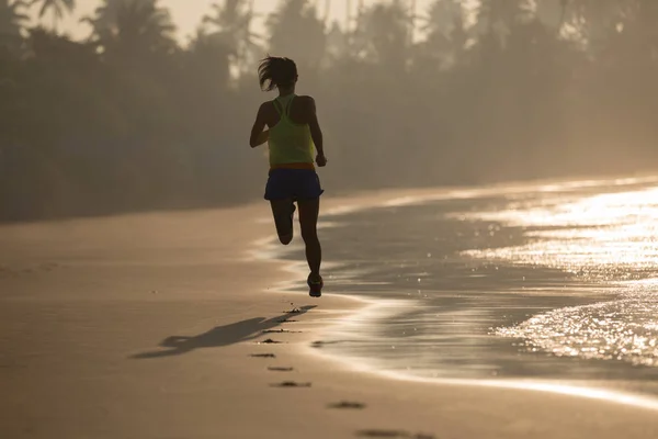 在日出海滩上跑步的健身女性 — 图库照片