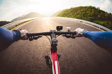 Otobanda bisiklet süren bisikletçilerin elleri