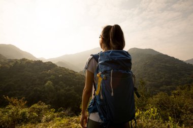 Dişi yürüyüşçü, sabah vadisinde manzaranın keyfini çıkarıyor.
