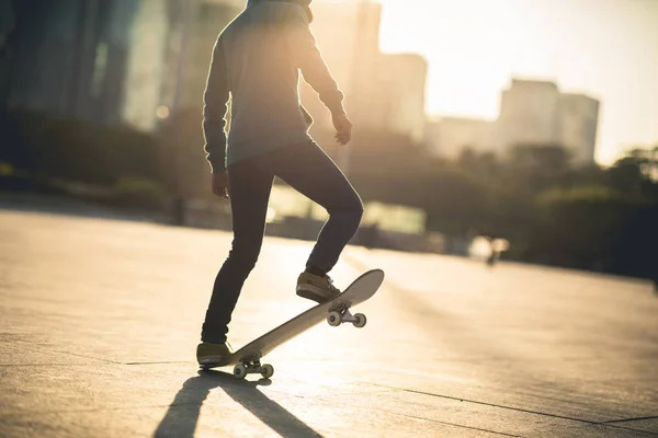 スケートボード現代都市の夕日でボードに乗る — ストック写真