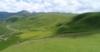 Güzel Çin dağları manzarasında yeşil çayırlar ve nehirler üzerindeki hava manzarası