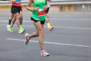 Şehir yolunda koşan maraton koşucuları